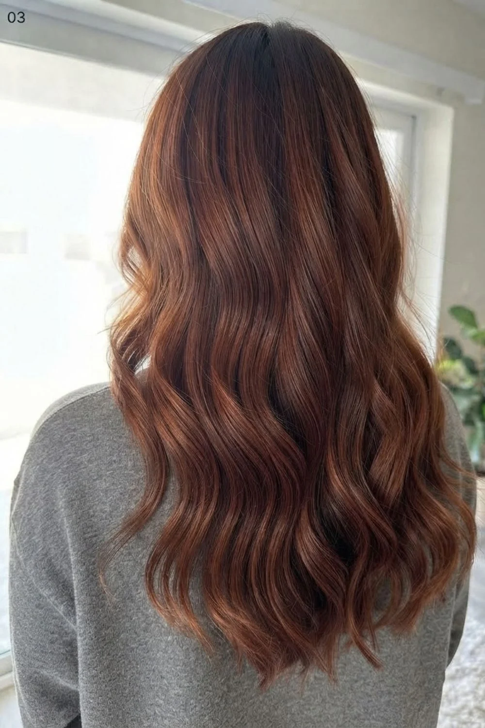 Rich cinnamon copper hair with soft waves and deeper brown-red dimension