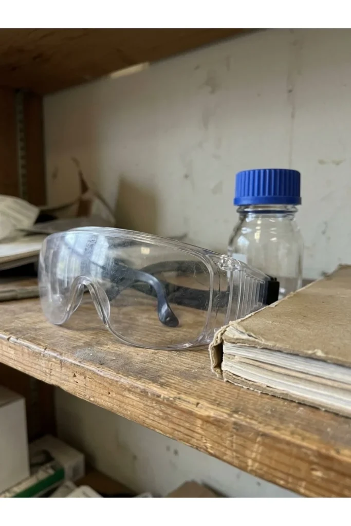 Safety goggles and laboratory supplies on a shelf in a learning space.