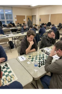 Several adults analyzing a chessboard at a public chess event.