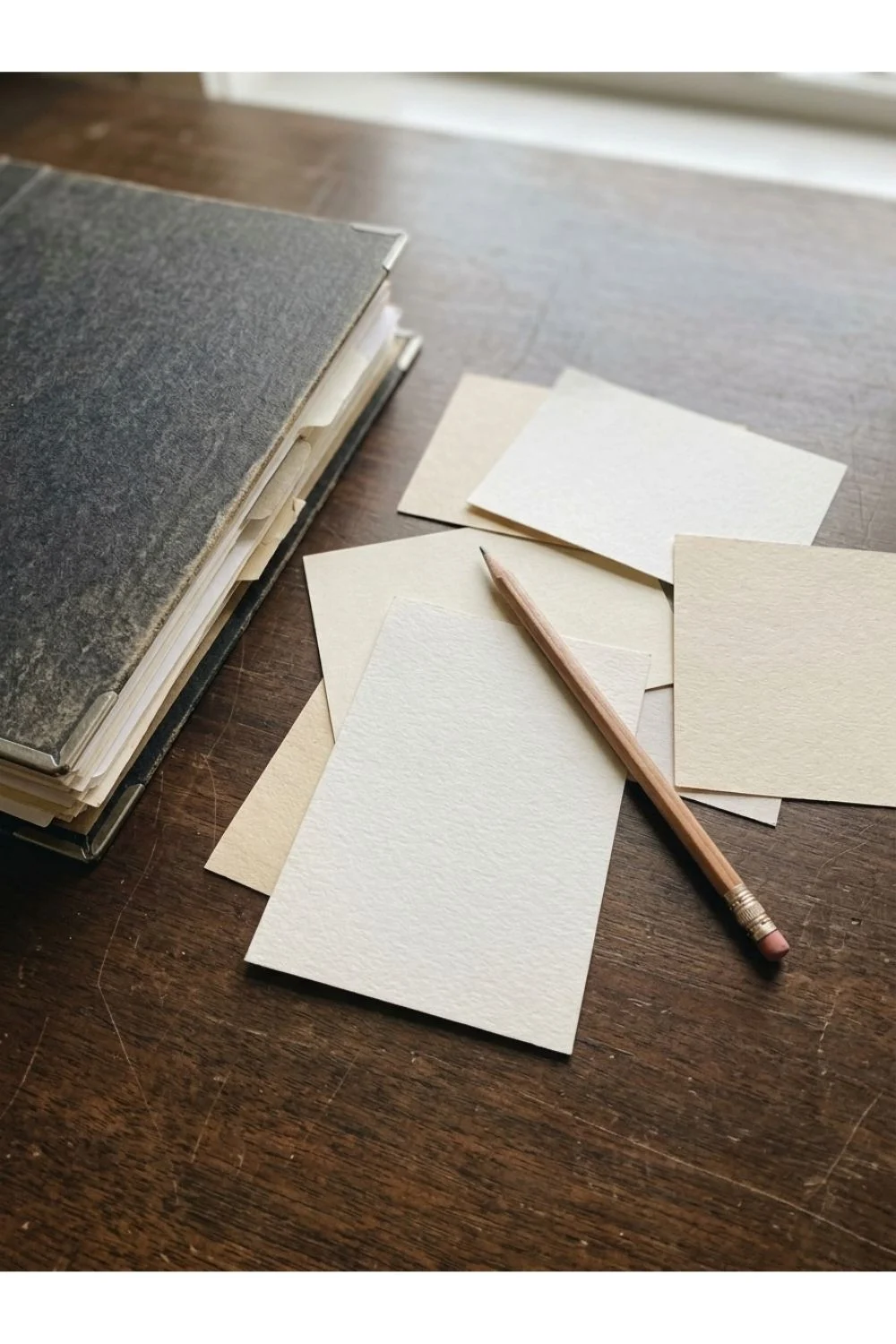 Plain blank paper and a pencil on a wooden tabletop.