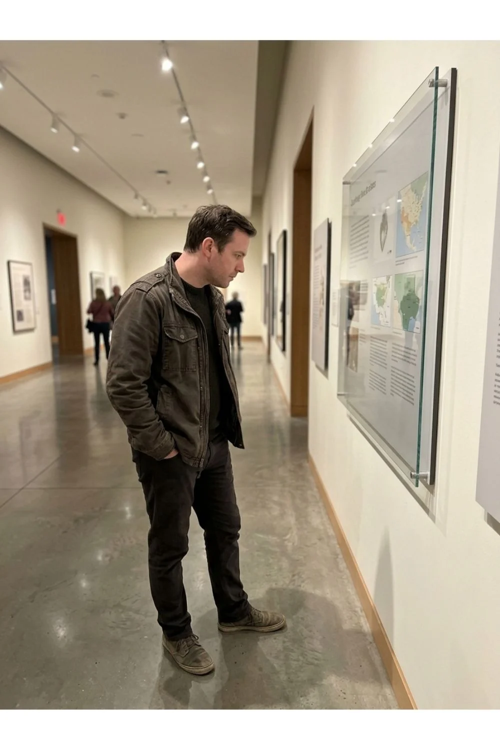 A person studying a framed painting in a small art gallery.
